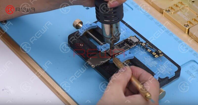 Attach the logic board to the PCB Holder. Heat with the QUICK 858D helical wind hot air gun at 280℃, air flow 5 and remove black adhesive around the NAND first.